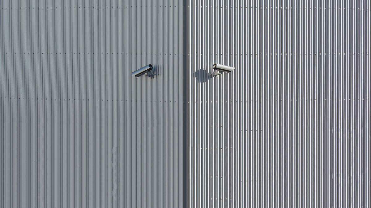 Technik podczas profesjonalnego montażu monitoringu – kamera CCTV mocowana na elewacji domu jednorodzinnego