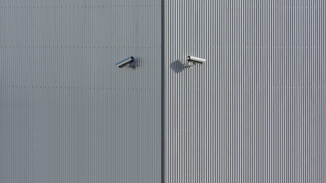 Technik podczas profesjonalnego montażu monitoringu – kamera CCTV mocowana na elewacji domu jednorodzinnego